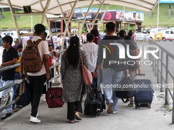 Nepali students are exiting the terminal of Tribhuvan International Airport upon arriving back in Kathmandu, Nepal, from violence-hit Bangla...