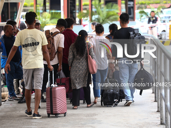 Nepali students are exiting the terminal of Tribhuvan International Airport upon arriving back in Kathmandu, Nepal, from violence-hit Bangla...