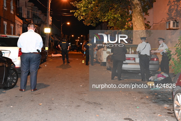 The crime scene unit is at the scene of a mass shooting with evidence markers placed on the ground, in Philadelphia, Pennsylvania, on July 2...