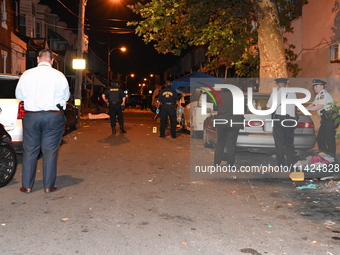 The crime scene unit is at the scene of a mass shooting with evidence markers placed on the ground, in Philadelphia, Pennsylvania, on July 2...