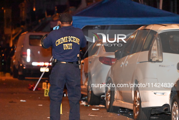 The crime scene unit is at the scene of a mass shooting with evidence markers placed on the ground, in Philadelphia, Pennsylvania, on July 2...