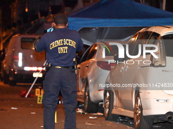 The crime scene unit is at the scene of a mass shooting with evidence markers placed on the ground, in Philadelphia, Pennsylvania, on July 2...