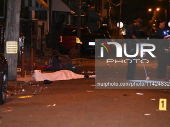 The crime scene unit is at the scene of a mass shooting with evidence markers placed on the ground, in Philadelphia, Pennsylvania, on July 2...