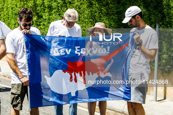 A group of Greek-Cypriots and Turkish-Cypriots is holding a bloodied Cyprus flag reading ''I don't forget,'' gathered at the Ledra Palace ch...