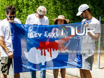 A group of Greek-Cypriots and Turkish-Cypriots is holding a bloodied Cyprus flag reading ''I don't forget,'' gathered at the Ledra Palace ch...