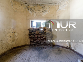 Sandbags behind a window are being seen inside an abandoned house next to the buffer zone, which is being used as a defensive point during t...