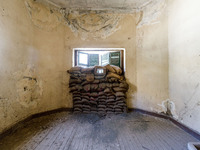 Sandbags behind a window are being seen inside an abandoned house next to the buffer zone, which is being used as a defensive point during t...