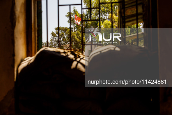 The flags of Turkey and the self-declared ''Turkish Republic of Northern Cyprus'' are being seen through a window of an abandoned house, whi...