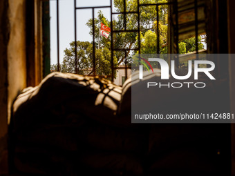 The flags of Turkey and the self-declared ''Turkish Republic of Northern Cyprus'' are being seen through a window of an abandoned house, whi...