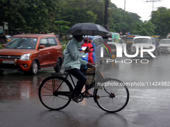 Commuters are being seen on the road as monsoon depression rain lashes in Bhubaneswar, Odisha, India. A deep depression is forming in the Ba...