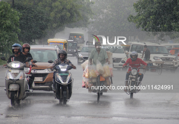 Commuters Are Seen On The Road As Monsoon Depression Rain Lashes In The Eastern Indian State Odisha's Capital City Bhubaneswar. A Deep Depre...