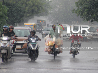 Commuters Are Seen On The Road As Monsoon Depression Rain Lashes In The Eastern Indian State Odisha's Capital City Bhubaneswar. A Deep Depre...