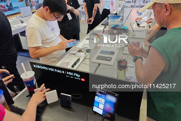 Customers are experiencing two fold-screen phones newly released by Xiaomi at a Xiaomi Home in Shanghai, China, on July 21, 2024. 