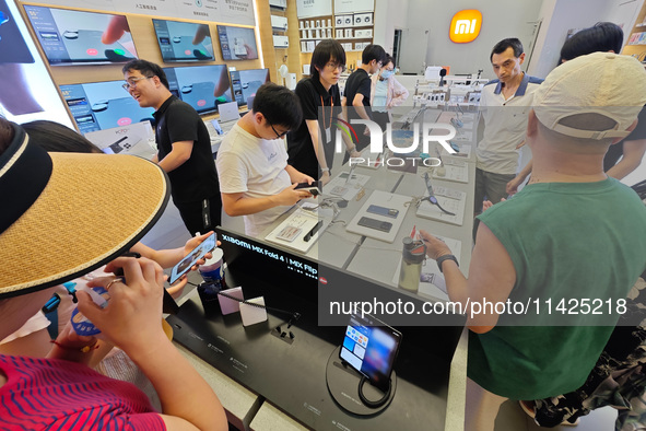 Customers are experiencing two fold-screen phones newly released by Xiaomi at a Xiaomi Home in Shanghai, China, on July 21, 2024. 