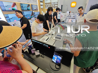 Customers are experiencing two fold-screen phones newly released by Xiaomi at a Xiaomi Home in Shanghai, China, on July 21, 2024. (