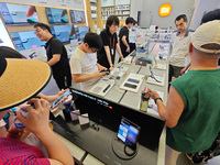 Customers are experiencing two fold-screen phones newly released by Xiaomi at a Xiaomi Home in Shanghai, China, on July 21, 2024. (