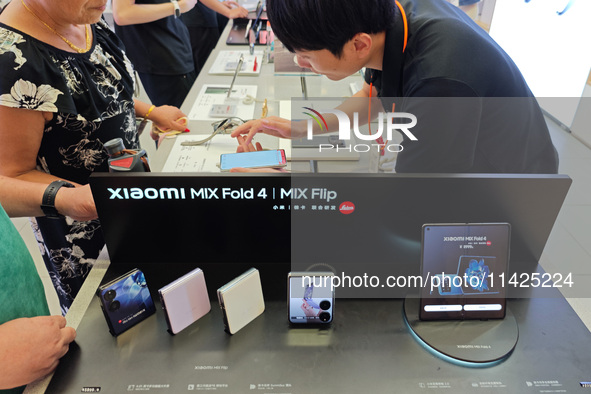 Customers are experiencing two fold-screen phones newly released by Xiaomi at a Xiaomi Home in Shanghai, China, on July 21, 2024. 