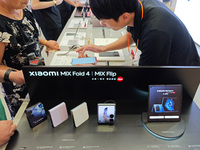 Customers are experiencing two fold-screen phones newly released by Xiaomi at a Xiaomi Home in Shanghai, China, on July 21, 2024. (