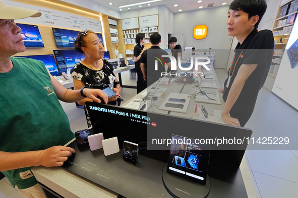 Customers are experiencing two fold-screen phones newly released by Xiaomi at a Xiaomi Home in Shanghai, China, on July 21, 2024. 