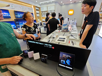 Customers are experiencing two fold-screen phones newly released by Xiaomi at a Xiaomi Home in Shanghai, China, on July 21, 2024. (