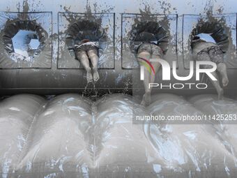 Visitors are playing in a mud pool at Mud Festival Park in Boryeong, South Korea. The Boryeong Mud Festival is an annual festival that takes...