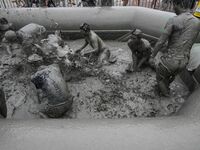 Visitors are playing in a mud pool at Mud Festival Park in Boryeong, South Korea. The Boryeong Mud Festival is an annual festival that takes...