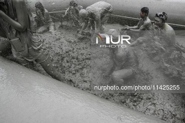 Visitors are playing in a mud pool at Mud Festival Park in Boryeong, South Korea. The Boryeong Mud Festival is an annual festival that takes...