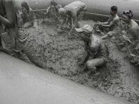 Visitors are playing in a mud pool at Mud Festival Park in Boryeong, South Korea. The Boryeong Mud Festival is an annual festival that takes...