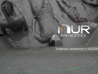 Visitors are playing in a mud pool at Mud Festival Park in Boryeong, South Korea. The Boryeong Mud Festival is an annual festival that takes...