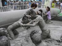 Visitors are playing in a mud pool at Mud Festival Park in Boryeong, South Korea. The Boryeong Mud Festival is an annual festival that takes...