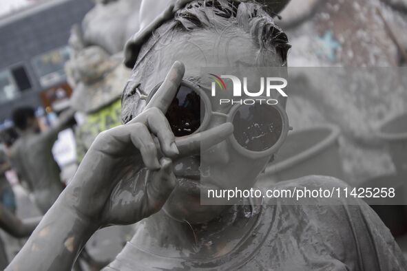 Visitors are playing in a mud pool at Mud Festival Park in Boryeong, South Korea. The Boryeong Mud Festival is an annual festival that takes...