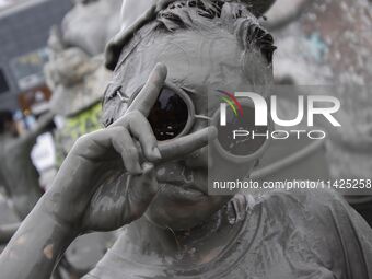 Visitors are playing in a mud pool at Mud Festival Park in Boryeong, South Korea. The Boryeong Mud Festival is an annual festival that takes...