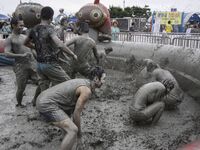 Visitors are playing in a mud pool at Mud Festival Park in Boryeong, South Korea. The Boryeong Mud Festival is an annual festival that takes...