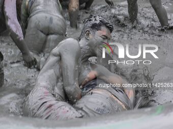 Visitors are playing in a mud pool at Mud Festival Park in Boryeong, South Korea. The Boryeong Mud Festival is an annual festival that takes...