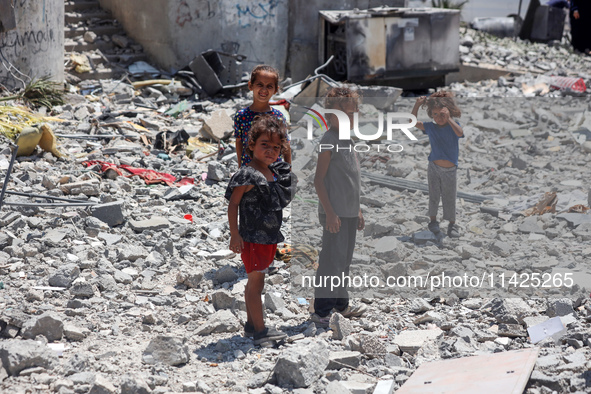 Palestinians are checking the rubble of buildings that were destroyed following an Israeli air strike on a residential building, amid the Is...