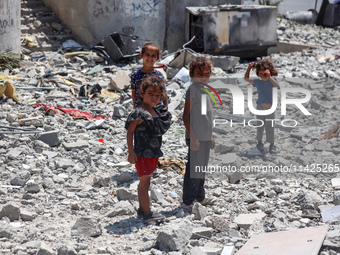 Palestinians are checking the rubble of buildings that were destroyed following an Israeli air strike on a residential building, amid the Is...