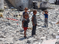 Palestinians are checking the rubble of buildings that were destroyed following an Israeli air strike on a residential building, amid the Is...