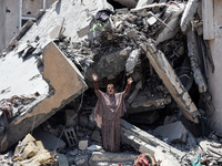 A Palestinian woman is gesturing near debris and destroyed vehicles in Nuseirat in the central Gaza Strip, on July 21, 2024, following an Is...