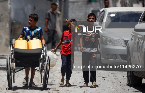 Palestinians are walking in front of a building damaged by Israeli bombardment in Nuseirat in the central Gaza Strip, on July 21, 2024, amid...