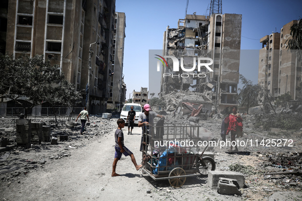 Palestinians are checking the rubble of buildings that were destroyed following an Israeli air strike on a residential building, amid the Is...