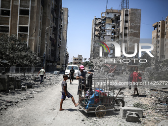 Palestinians are checking the rubble of buildings that were destroyed following an Israeli air strike on a residential building, amid the Is...