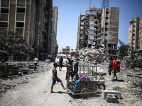 Palestinians are checking the rubble of buildings that were destroyed following an Israeli air strike on a residential building, amid the Is...