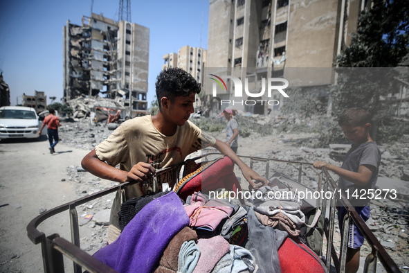 Palestinians are checking the rubble of buildings that were destroyed following an Israeli air strike on a residential building, amid the Is...