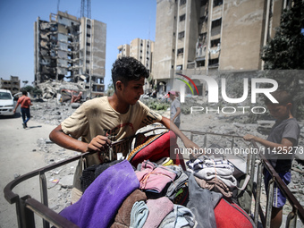 Palestinians are checking the rubble of buildings that were destroyed following an Israeli air strike on a residential building, amid the Is...