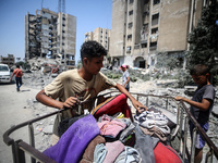 Palestinians are checking the rubble of buildings that were destroyed following an Israeli air strike on a residential building, amid the Is...