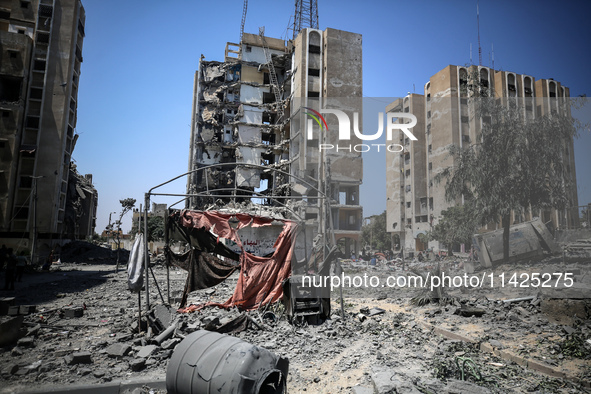 Palestinians are checking the rubble of buildings that were destroyed following an Israeli air strike on a residential building, amid the Is...