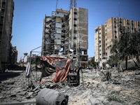 Palestinians are checking the rubble of buildings that were destroyed following an Israeli air strike on a residential building, amid the Is...