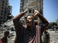 A Palestinian woman is gesturing near debris and destroyed vehicles in Nuseirat in the central Gaza Strip, on July 21, 2024, following an Is...