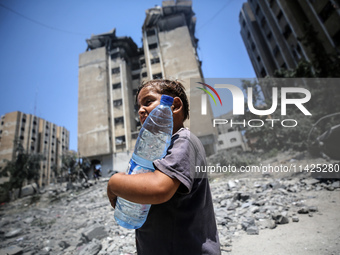 Palestinians are walking in front of a building damaged by Israeli bombardment in Nuseirat in the central Gaza Strip, on July 21, 2024, amid...