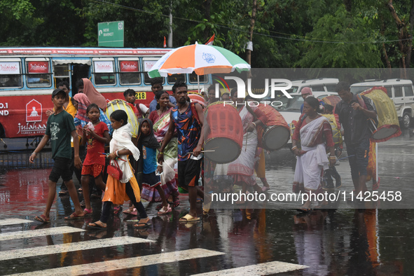 People are walking on the street in the rain in Kolkata, India, on July 21, 2024. 